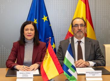 Imagen de una mujer y un hombre sentados en una sala de reuniones.