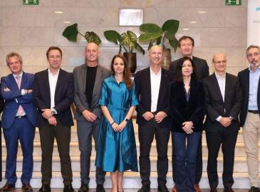 Un Grupo de personas posando en una escalera interior durante un acto corporativo, con un cartel de Ship2B Ventures visible al fondo.