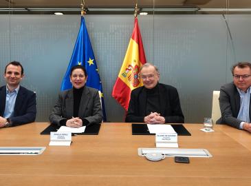 Cuatro personas sentadas en una mesa posando para la fotografía. 