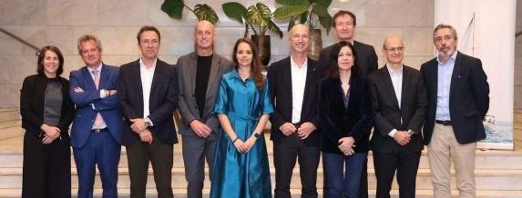 Un Grupo de personas posando en una escalera interior durante un acto corporativo, con un cartel de Ship2B Ventures visible al fondo.