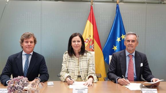 A group of three people seated at a table, posing for the camera.