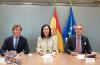 Imagen de tres personas en una sala de reuniones posando para una foto.